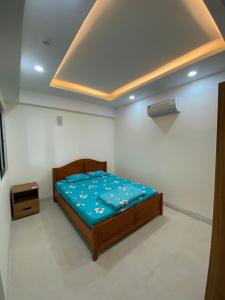1 dormitorio con 1 cama con edredón azul en Coastal House Nha Trang en Nha Trang