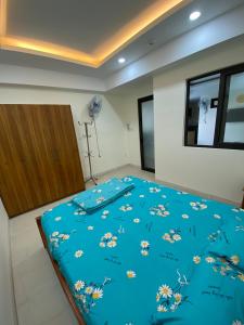 a bedroom with a blue comforter with flowers on it at Coastal House Nha Trang in Nha Trang