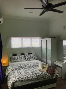 a bedroom with a bed and a ceiling fan at Bendang Homes - Sekinchan Homestay in Kampong Sungai Leman