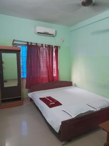 een slaapkamer met een bed met een spiegel en een raam bij Goroomgo Star Inn Digha Near Sea Beach - Lift & Parking Facilities - Best Seller in Digha