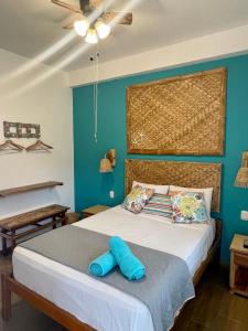 1 dormitorio con 1 cama con pared azul en Qeru House, en Zorritos