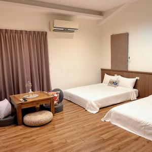 een hotelkamer met 2 bedden en een tafel bij Landay Homestay in Yilan
