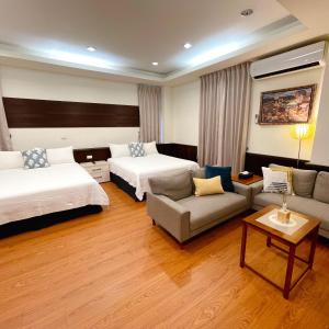 Habitación de hotel con 2 camas y sofá en Landay Homestay, en Yilan City