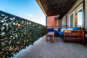 a patio with a blue couch and a plant at Bright Luxe Condo, AC, Top Floor, King Bed, Balcony! in Edmonton