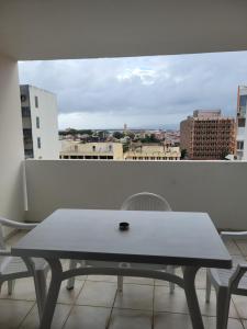 una mesa en un balcón con vistas a la ciudad en Le 9ème étage du bonheur, en Pointe-à-Pitre