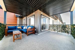 a patio with a couch and a table on a balcony at Bright Luxe Condo, AC, Top Floor, King Bed, Balcony! in Edmonton