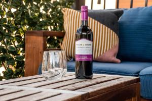 a bottle of wine sitting on a table next to a glass at Bright Luxe Condo, AC, Top Floor, King Bed, Balcony! in Edmonton +59 photos