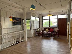 a room with a table and chairs and windows at At Home Phetchaboon in Phetchabun