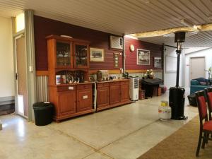 a living room with wooden cabinets and a kitchen at Chrissie's Dongara in Kimba