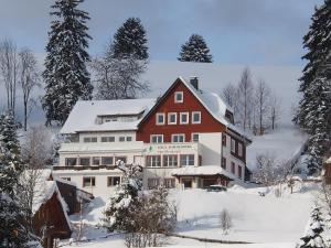 ein großes rotweißes Haus im Schnee in der Unterkunft Haus Sommerberg in Feldberg