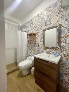 uma casa de banho com um WC, um lavatório e um espelho. em Qeru House em Zorritos