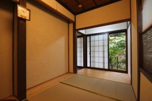 Habitación vacía con puerta y ventana en 農家民宿 山いちご, en Echizen