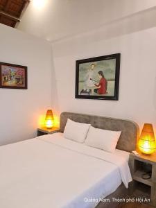 ein Schlafzimmer mit einem großen Bett und zwei Lampen in der Unterkunft BOBE Homestay in Hoi An