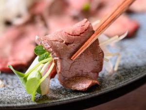 um pedaço de carne num prato com pauzinhos em Hotel Tsu Center Palace em Tsu