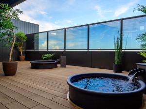 津市的住宿－Hotel Tsu Center Palace，植物丛生建筑屋顶上的热水浴池