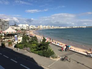 Blick auf den Strand mit Menschen und das Meer in der Unterkunft T3 face plage avec balcon et parking, aux Sables-d'Olonne - FR-1-92-808 in Les Sables-dʼOlonne