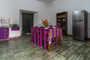 a kitchen with a table with purple chairs and a refrigerator at Dragonfly Guest House in Sucre