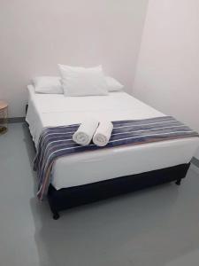 ein Bett mit zwei Handtüchern darüber in der Unterkunft Aloja-T en Apartamento amoblado SIN balcón en Ciudad Bolivar in Ciudad Bolívar