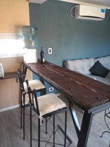escritorio con 2 sillas y cama en una habitación en Balcon al Valle Grande, San Rafael Mendoza en Valle Grande