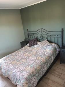 a bedroom with a large bed with a comforter at Balcon al Valle Grande, San Rafael Mendoza in Valle Grande
