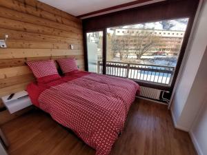 a bedroom with a bed and a large window at Appartement Les Deux Alpes, 2 pièces, 4 personnes - FR-1-516-200 in Les Deux Alpes