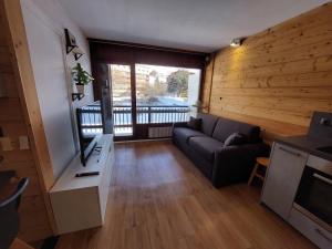 a living room with a couch and a large window at Appartement Les Deux Alpes, 2 pièces, 4 personnes - FR-1-516-200 in Les Deux Alpes