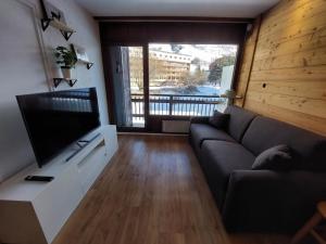 sala de estar con sofá y TV de pantalla plana en Appartement Les Deux Alpes, 2 pièces, 4 personnes - FR-1-516-200 en Les Deux Alpes