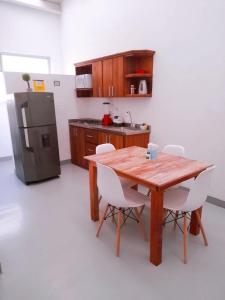Il comprend une cuisine équipée d'une table en bois et d'un réfrigérateur. dans l'établissement Aloja-T en Apartamento amoblado 4 en Ciudad Bolivar, à Ciudad Bolívar