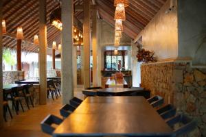 un restaurante con una gran mesa de madera y sillas en Hiru Resort and Kite Surfing en Kalpitiya
