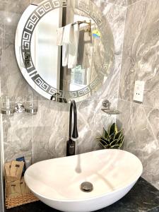 Sel de Mer Apartment Grand World Phu Quoc في فو كووك: بالوعة بيضاء في الحمام مع مرآة