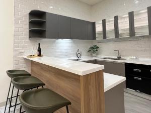 a kitchen with a counter with stools and a sink at Lin House in Checheng