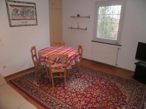 ein Esszimmer mit einem Tisch, Stühlen und einem Teppich in der Unterkunft Appartamento Posmonte in Agra