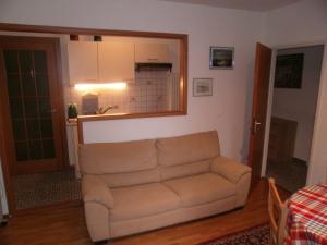 ein Wohnzimmer mit einem Sofa und einer Küche in der Unterkunft Appartamento Posmonte in Agra
