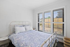 a bedroom with a bed and a large window at McMillan Escape in Anglesea