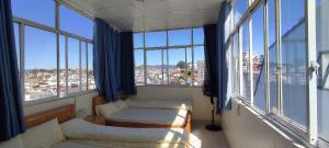 a room with two beds and large windows at Homestay Dalat Xinh in Da Lat