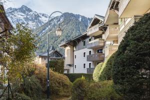 un éclairage de rue devant un bâtiment avec des montagnes dans l'établissement La Ginabelle - Sauna & Swimming pool - Happy Rentals, à Chamonix-Mont-Blanc