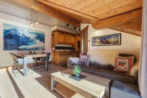 a living room with a couch and a table at La Ginabelle - Sauna & Swimming pool - Happy Rentals in Chamonix-Mont-Blanc
