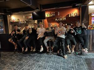 un grupo de personas sentadas en un bar posando para una foto en Bong Hostel and Motorbike Tour, en Ha Giang