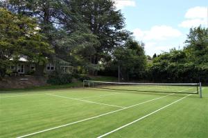 um campo de ténis com uma rede num relvado em Robin Hill Manor em Moss Vale