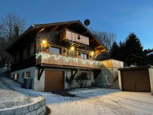a house with a balcony and a garage at CHALET-MICHEL avec SPA in Montperreux