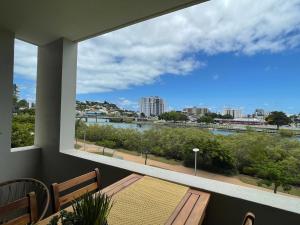 a balcony with a table and a view of a river at City Stadium Apartment on the Riverfront 38 in Townsville