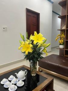 a vase of yellow flowers on a table in a living room at Sai Gon Motel in Da Nang