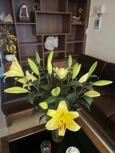 a vase with yellow flowers on a table in a living room at Sai Gon Motel in Da Nang