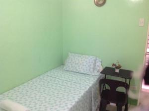 um pequeno quarto com uma cama e uma mesa em Sinoben Apartments by RedDoorz em Santa Barbara