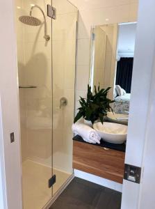 La salle de bains est pourvue d'une douche en verre et d'un lavabo. dans l'établissement Great Ocean Road Wellness and Nature Stay, à Apollo Bay