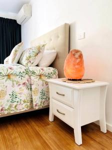 Un dormitorio con una cama y una mesa con un jarrón. en Great Ocean Road Wellness and Nature Stay en Apollo Bay