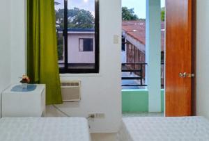 um quarto com uma cama e vista para uma varanda em Sinoben Apartments by RedDoorz em Santa Barbara