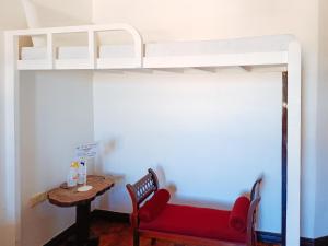 1 dormitorio con litera, sofá rojo y mesa en Hotel Elinas and Restaurant, en Tuguegarao
