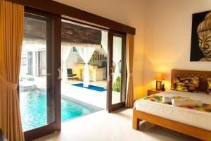 a bedroom with a bed and a swimming pool at Wyanna Villa LEGIAN in Legian