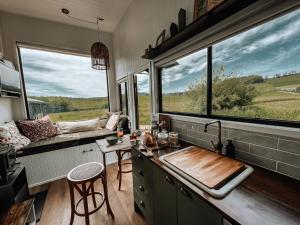 een keuken met een wastafel en een groot raam bij Shepherd & Sprout Boutique Tiny House - Cradle Country in Wilmot